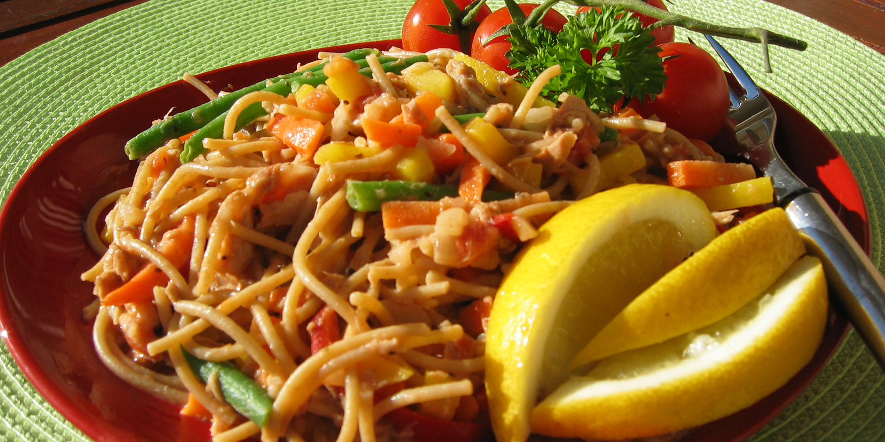 Lautasella annos pätkäspagettia, tonnikalakastiketta ja sitruunalohkoja