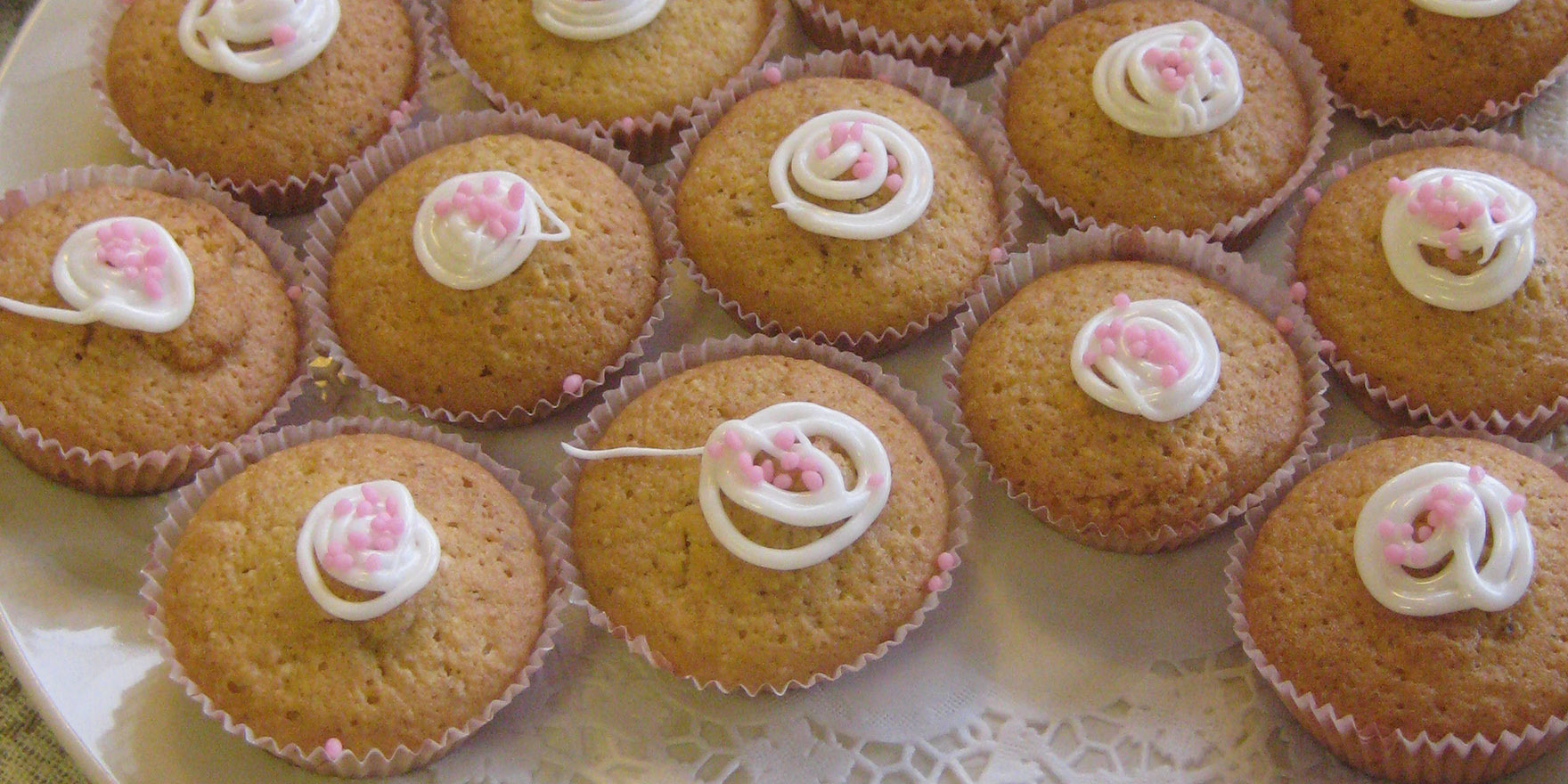 Ryhmä vaaleita pikeerillä koristeltuja kirsikkamuffineita leivosvuoissa