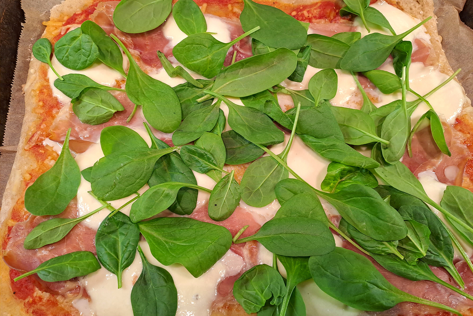 Kuvassa Pulla-tytön tekemä peltipizza parmankinkulla, juustolla ja babypinaatilla