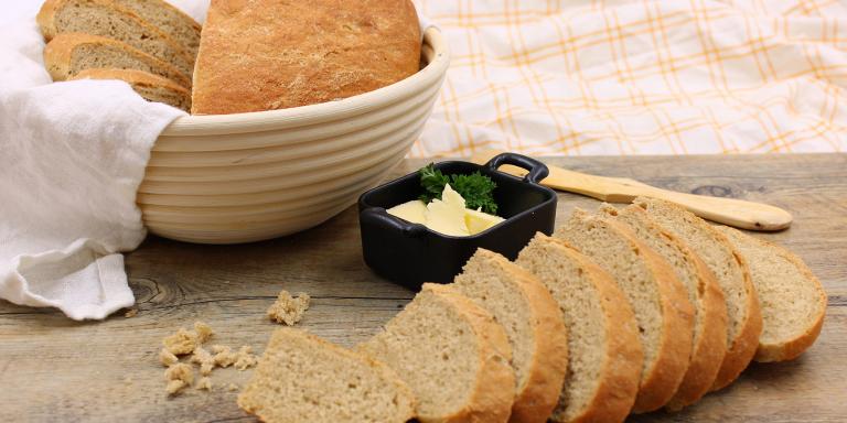 Leipäviipaleita pöydällä, voita pikku kipossa, veitsi ja leipäviipaleita kulhossa