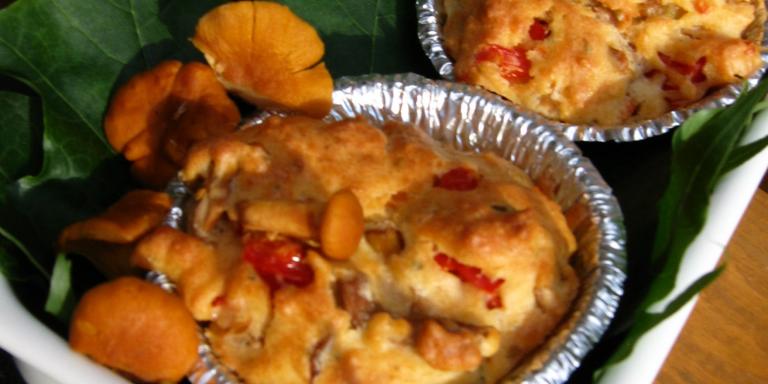 Kaksi pientä muffinia metallivuoassa sekä kantarelleja koristeena