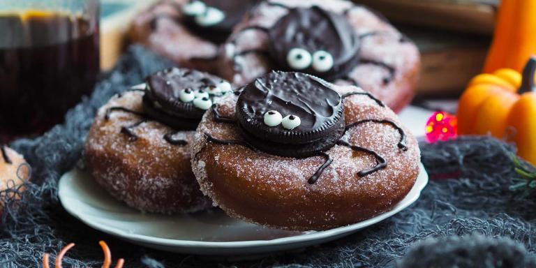 Halloween-donitsit, joissa donitsin päälle on keksistä koristeltu hämähäkki.