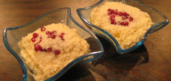 Kaksi annoskulhoa riisifrutista, pinnalla kookoshiutaleita ja punaisia marjoja