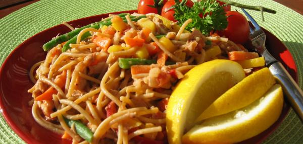 Lautasella annos pätkäspagettia, tonnikalakastiketta ja sitruunalohkoja