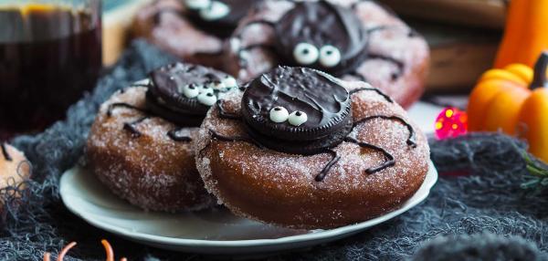 Halloween-donitsit, joissa donitsin päälle on keksistä koristeltu hämähäkki.