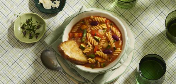 Kulhollinen kasvisminestronekeittoa katettuna pöytään