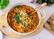 Padallinen tagliatelle al Ragúa pöydällä parmesaanin ja basilikaruukun kera