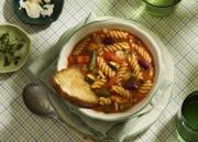 Kulhollinen kasvisminestronekeittoa katettuna pöytään