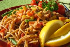 Lautasella annos pätkäspagettia, tonnikalakastiketta ja sitruunalohkoja