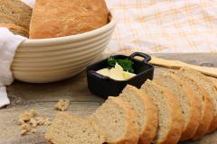 Leipäviipaleita pöydällä, voita pikku kipossa, veitsi ja leipäviipaleita kulhossa