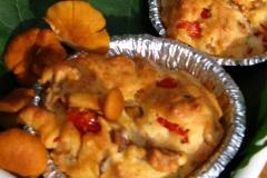 Kaksi pientä muffinia metallivuoassa sekä kantarelleja koristeena